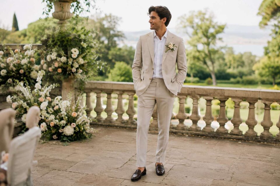 Marié élégant en costume beige élégant portant des mocassins marron. Se demander "peut-on porter des mocassins pour homme à son mariage" trouve ici une illustration parfaite.